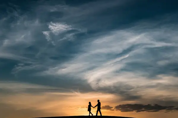 Coppia in silhouette al tramonto, un'immagine che evoca una poesia per 60 anni di matrimonio, un amore che dura nel tempo.